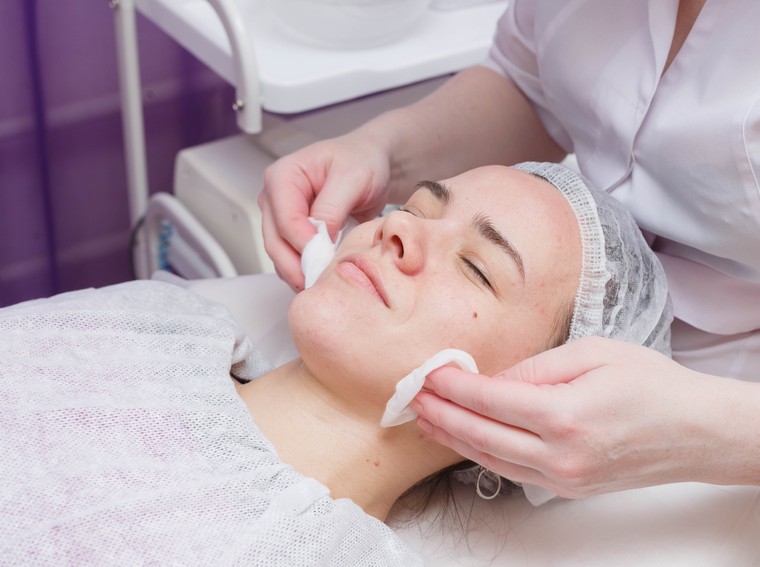mulher recebendo tratamento facial em clínica de estética
